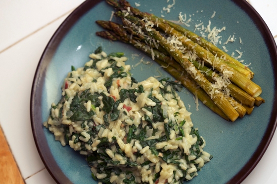 Risotto served with lemon pepper asparagus on a blue stoneware plate