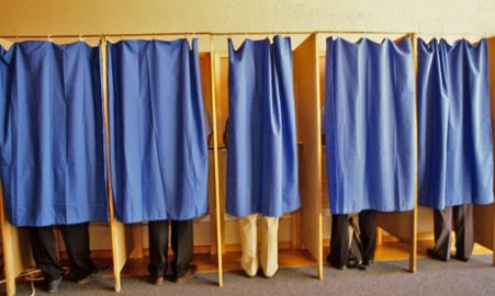 people voting behind curtains at polling booths